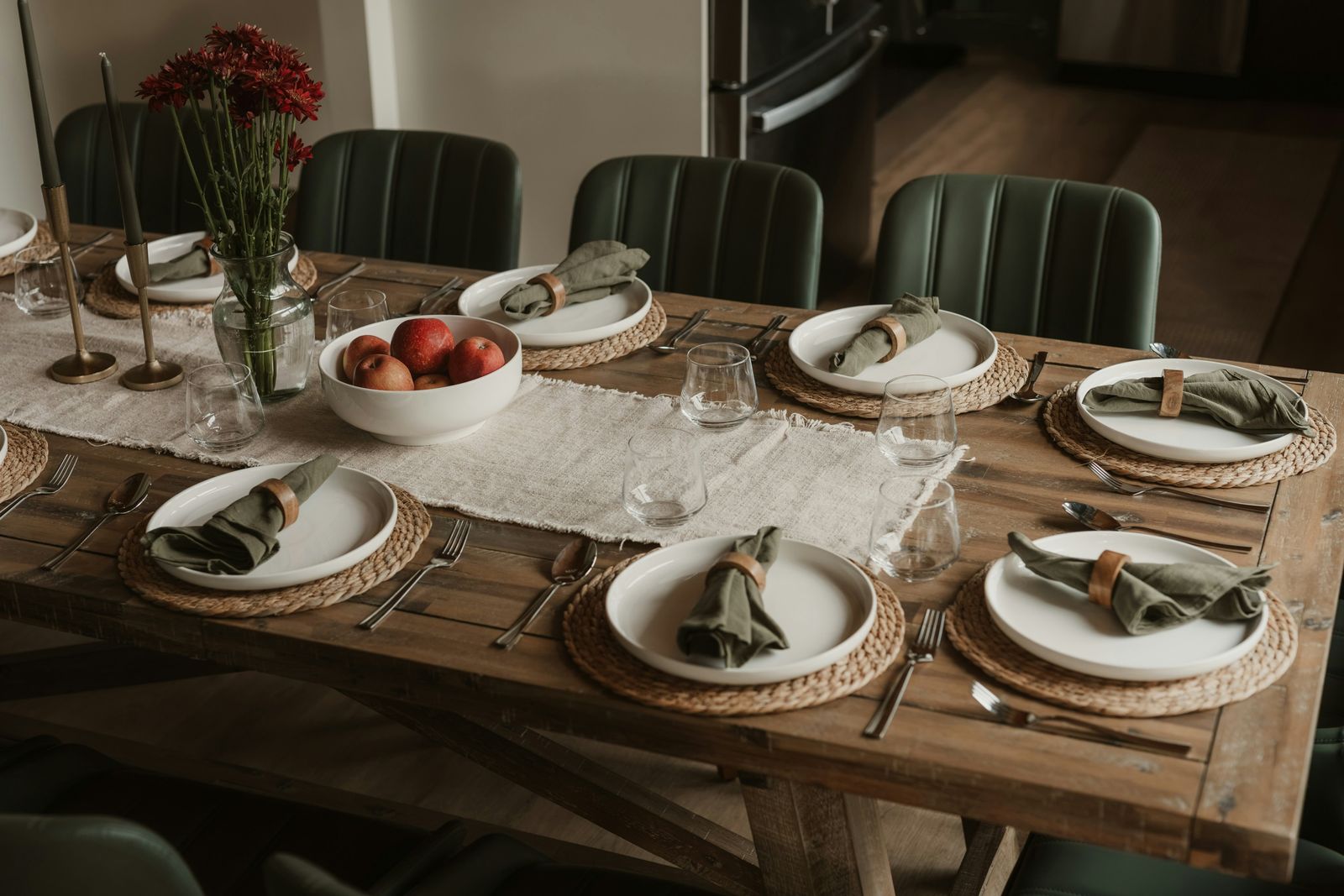 Dining table set with white plates, cloth napkins, and apples for fall