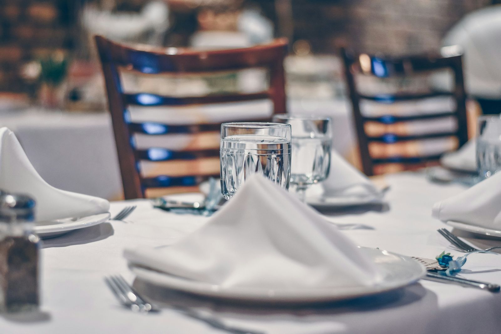 Restaurant table set with white linens and glassware
